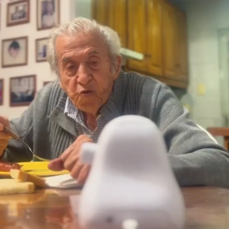 Carlos sentado a la mesa con Ato adelante